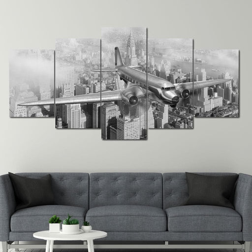 DC-3 Over New York - Canvas Print - black and white wall art of an airplane flying over the city - this vintage home decor is made with high quality canvas and ink | NicheCanvas