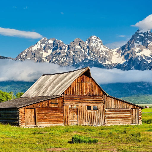 The Old Barn - Canvas Print - gorgeous wall art of a wooden barn and a stunning view of the mountains on a cloudy day - this is the perfect centerpiece for your cozy home | NicheCanvas